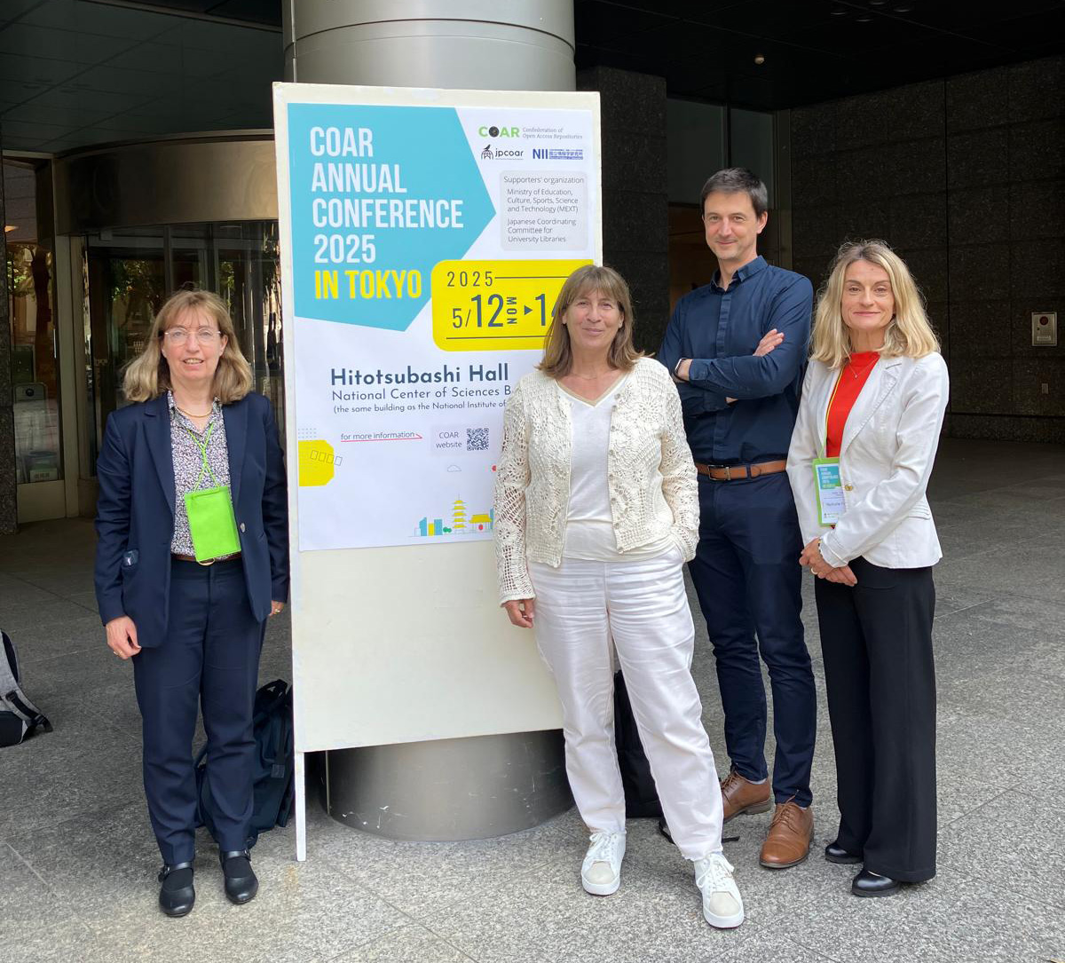 photo de groupe des membres de l'équipe CCSD prise devant l'affiche de la conférence annuelle COAR